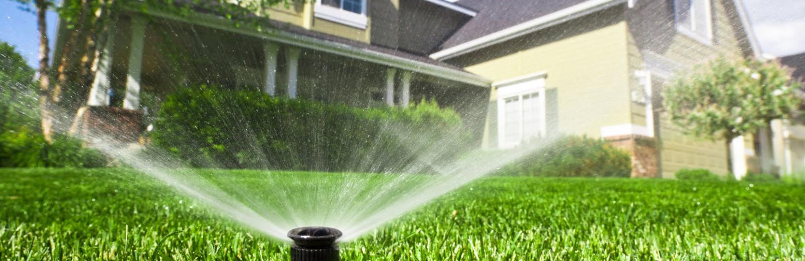 sprinkler system spraying water on lawn 