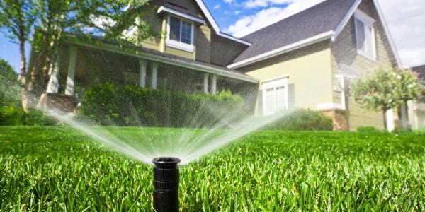 sprinkler system spraying water on lawn 